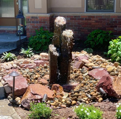 bubbling rocks in rock garden with flowers